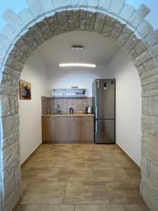 een boog in een keuken met een koelkast bij Katerina Apartments & Studios in Naousa
