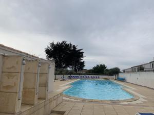 een leeg zwembad in een gebouw bij Jolie maison en residence - paradis des familles - Re Liberte in La Flotte