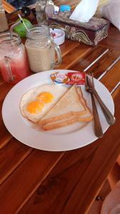 un piatto bianco con un uovo e un toast su un tavolo di Perdana Homestay Lembongan a Nusa Lembongan