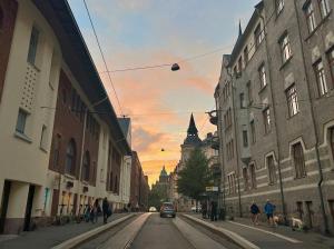 een stadsstraat met een zonsondergang op de achtergrond bij Oceanic & trendy two bedroom apartment with FREE parking in Helsinki