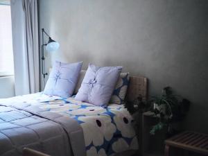 een slaapkamer met een bed met blauwe en witte lakens en kussens bij Oceanic & trendy two bedroom apartment with FREE parking in Helsinki