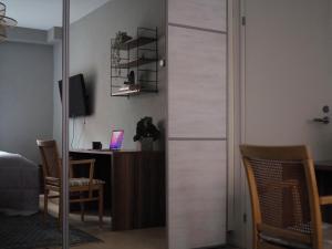 ヘルシンキにあるOceanic & trendy two bedroom apartment with FREE parkingのデスク、ガラスのスライドドアが備わる客室です。