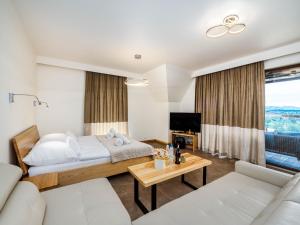 a bedroom with a bed and a living room at Apartamenty Hrube Niżne 23D in Zakopane