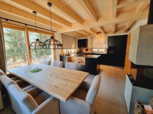 kuchnia i jadalnia z drewnianym stołem i krzesłami w obiekcie Mei-Chalet w mieście Bad Kleinkirchheim