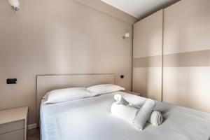 ミラノにあるCampanini Apartmentのベッドルーム1室(白いベッド1台、タオル付)