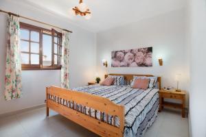 a bedroom with a wooden bed and a window at Casa Aloe in Haría