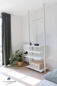 Dormitorio blanco con cama y estante blanco en Stilvolles Apartment im Zentrum mit Netflix WE23 en Magdeburgo