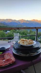 a table with a plate of meat and cheese on it at Appartement 2 Chbres Calme Vue vallée 500m des pistes in Villarembert