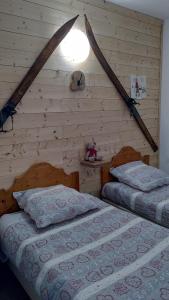 sypialnia z 2 łóżkami i lampką na ścianie w obiekcie Appartement 2 Chbres Calme Vue vallée 500m des pistes w mieście Villarembert