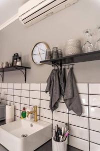 a kitchen with a sink and a clock on the wall at Excellently located close to N1, Free WIFI, SMART TV, Easy Self Check in, Modern and many RESTAURANTS on premises in Bloemfontein