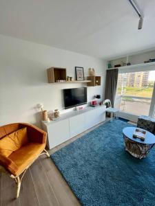 a living room with a tv and a couch and a table at Appartement 't Pand in Nieuwpoort