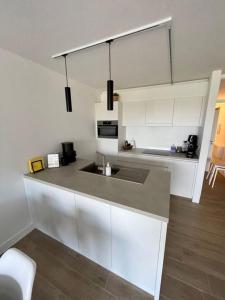 a kitchen with white cabinets and a counter top at Appartement 't Pand in Nieuwpoort