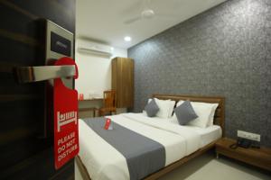 a bedroom with a bed with a red sign on it at The Pacific Hotel in Vadodara