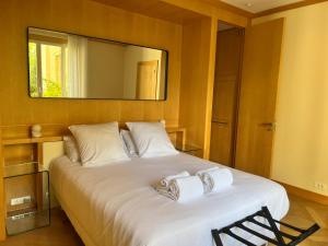 una camera da letto con un grande letto bianco e uno specchio di La Villa d'Auteuil a Parigi