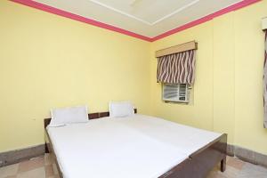 1 dormitorio con 1 cama blanca grande en una habitación en OYO Hotel Surya, en Rourkela