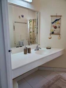 a white bathroom with a sink and a mirror at 6 Sandy Surf, Worthing Christ Church in Christ Church