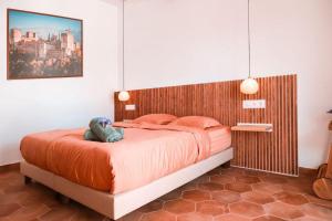 a bedroom with a bed with a stuffed animal on it at Finca Besito in Alhaurín el Grande