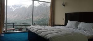 a bedroom with a bed and a large window at Venus Mountain Resort, Hunza in Hunza