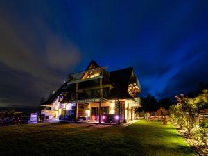 a large house at night with lights at Apartamenty Hrube Niżne 23D in Zakopane
