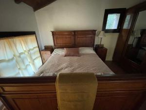 a bedroom with a large bed with a wooden headboard at Agriturismo Mulino in Pietra in Casina