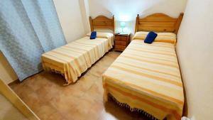 two beds in a small room with at Apartamento portil in El Portil