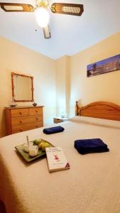 a bed with a tray of fruit and a sign on it at Apartamento portil in El Portil