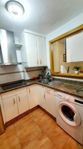 a kitchen with a washing machine and a sink at Apartamento portil in El Portil