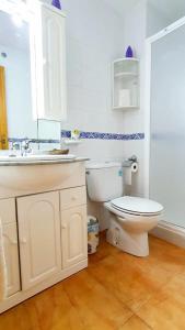 a white bathroom with a toilet and a sink at Apartamento portil in El Portil
