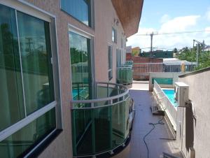 - un balcon dans un immeuble avec piscine dans l'établissement POUSADA CAMINHO DAS ÁGUAS, à Arraial do Cabo