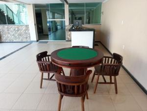 une table avec quatre chaises et un comptoir vert dans l'établissement POUSADA CAMINHO DAS ÁGUAS, à Arraial do Cabo