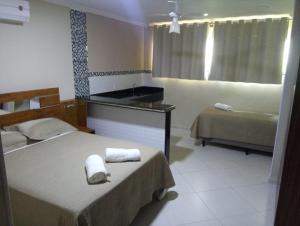 Habitación de hotel con 2 camas y lavamanos en POUSADA CAMINHO DAS ÁGUAS, en Arraial do Cabo