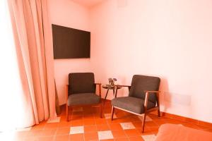 two chairs in a room with a table and a tv at Finca Besito in Alhaurín el Grande