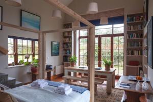 a room with a bed and a table and bookshelves at The Stable Yard House at Burtown House & Gardens in Athy