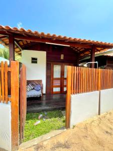 una valla de madera frente a una casa en Chalés Paradise en Atins