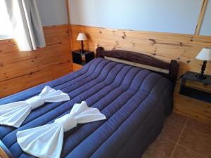 a bedroom with a blue bed with white pillows at Los Nopo in Trevelin