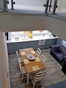 a kitchen with a wooden table and chairs and a couch at Apartament Old England in Żywiec