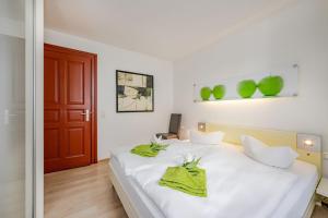 - une chambre avec un lit blanc et des serviettes vertes dans l'établissement Villa Medici 10 a, à Ahlbeck