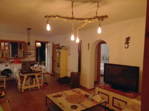 a living room with a flat screen tv and a table at Casa Ohanna Lugar idílico en plena naturaleza in El Soto