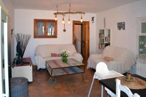a living room with two white couches and a table at Casa Ohanna Lugar idílico en plena naturaleza in El Soto