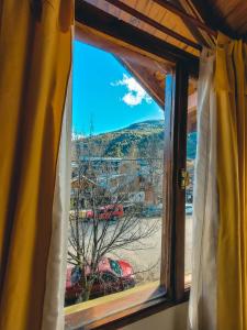 d'une fenêtre avec vue sur la montagne. dans l'établissement La Vista Monoambiente CENTRO, à San Martín de los Andes