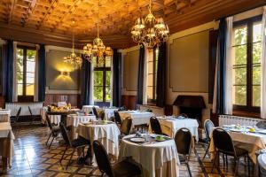 un comedor con mesas, sillas y lámparas de araña en Hotel Rural y Apartamentos Villa Engracia, en Espluga de Francolí