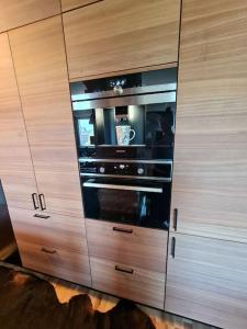 a wooden cabinet with an oven in a kitchen at ROVIO ART APARTMENTS Gummeruksenkatu 5 Jyväskylä in Jyväskylä +2 photos