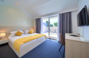 a hotel room with a bed and a desk and a window at Hotel Bor in Krk