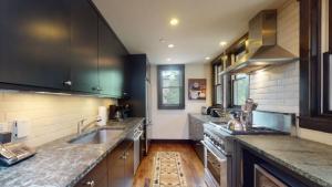 a large kitchen with a sink and a stove at Ski In, Ski Out, 3 Bedroom Luxury Residence On Fanny Hill In Snowmass Village in Snowmass Village