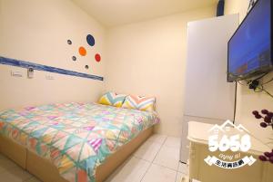 a bedroom with a bed and a flat screen tv at Fengjia Line Stack in Taichung