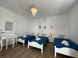 a room with two beds and a table and a mirror at Katerina Apartments & Studios in Naousa