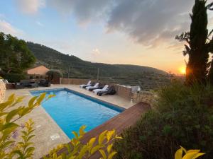 a villa with a swimming pool with a sunset at עיינות ספיר - Einot Sapir in Sappir