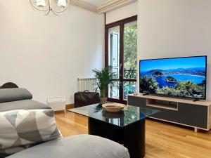 sala de estar con TV de pantalla plana sobre una mesa en Avenida 12 apartment, en San Sebastián