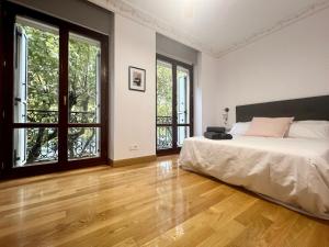 1 dormitorio con 1 cama y 2 ventanas en Avenida 12 apartment, en San Sebastián