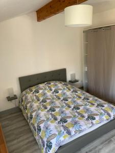 1 dormitorio con 1 cama con edredón en Le Matadri, en Grane